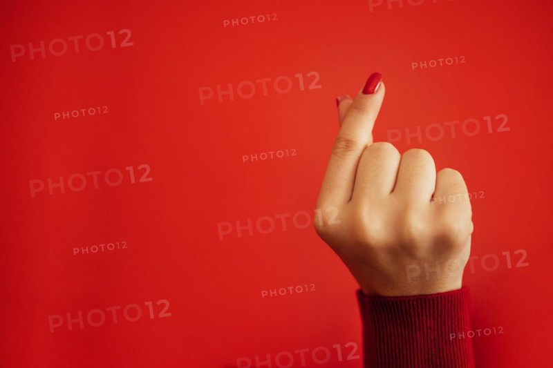 The Korean symbol for love is obvious. A woman's hand covers a heart. Place for text. Happy Valentine's day