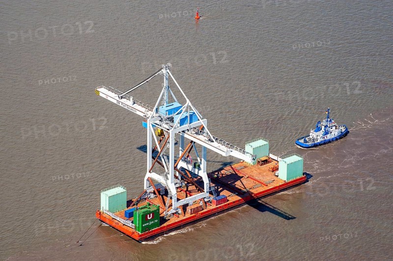 Tugboat with heavy load on a pontoon on the Elbe