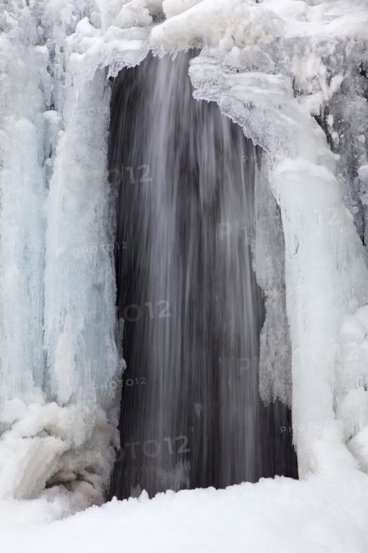 Frozen waterfall Kirkjufellsfoss on the Snaefellsnes peninsula in winter