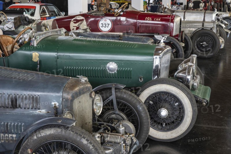 Historic racing cars lined up in a car park