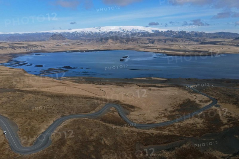 Road to the small peninsula of Dyrholaey on the south coast with a view of the glacier Myrdalsjoekull