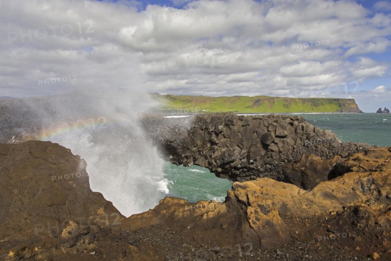 Wave crashing under natural arch