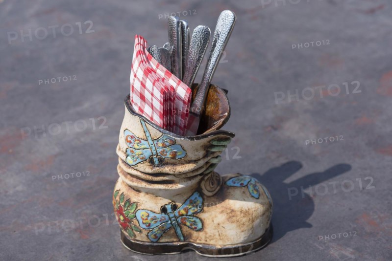 Ceramic boots as cutlery and napkin holder in a restaurant