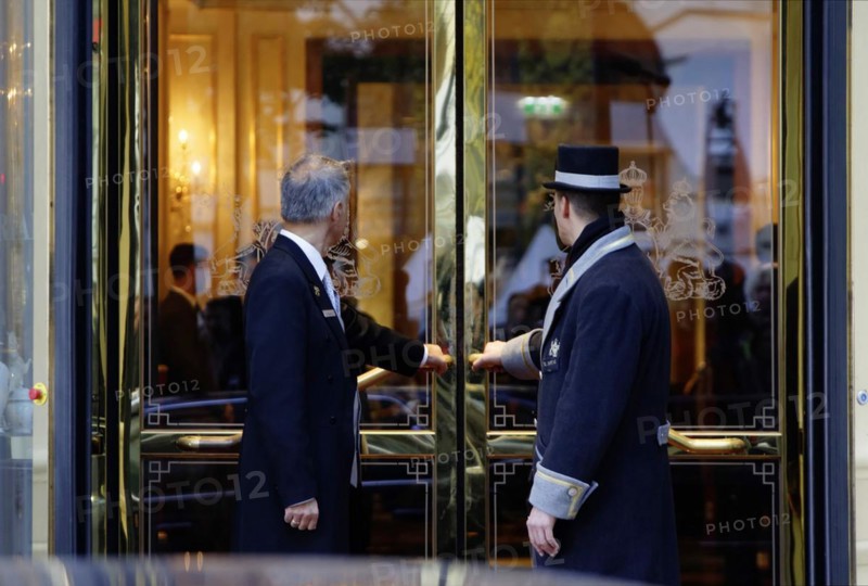 A uniformed car attendant and a concierge of the Hotel Imperial open the hotel door