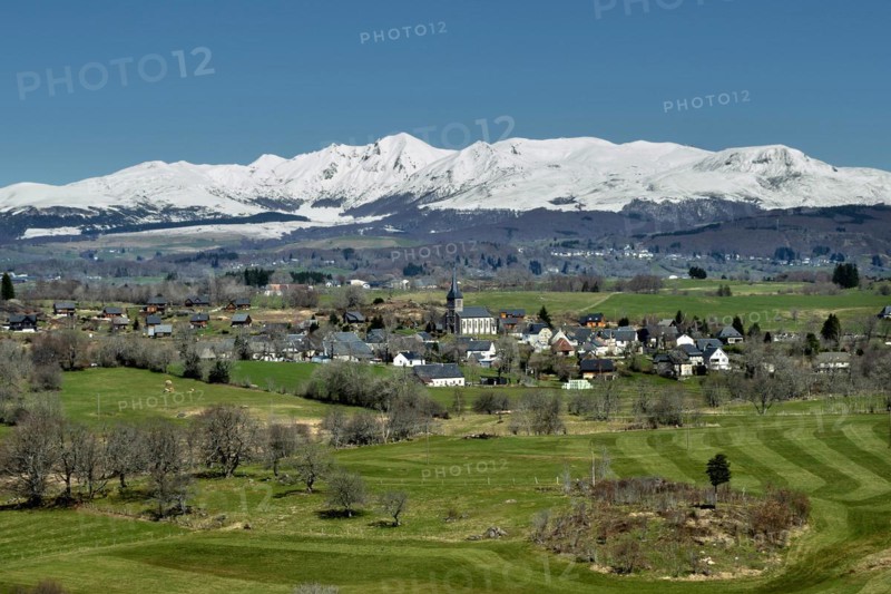 Regional natural park of the Volcanoes of Auvergne. View on the village of Saint Genes Champespe and the Monts Dore in winter. Puy de Dome department. Auvergne-Rhone-Alpes. France