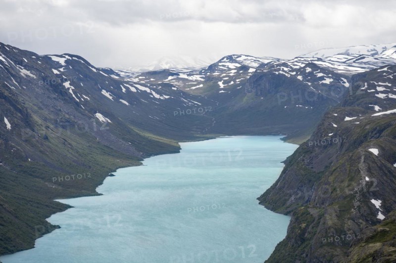 View of Lake Gjende and snowy mountains