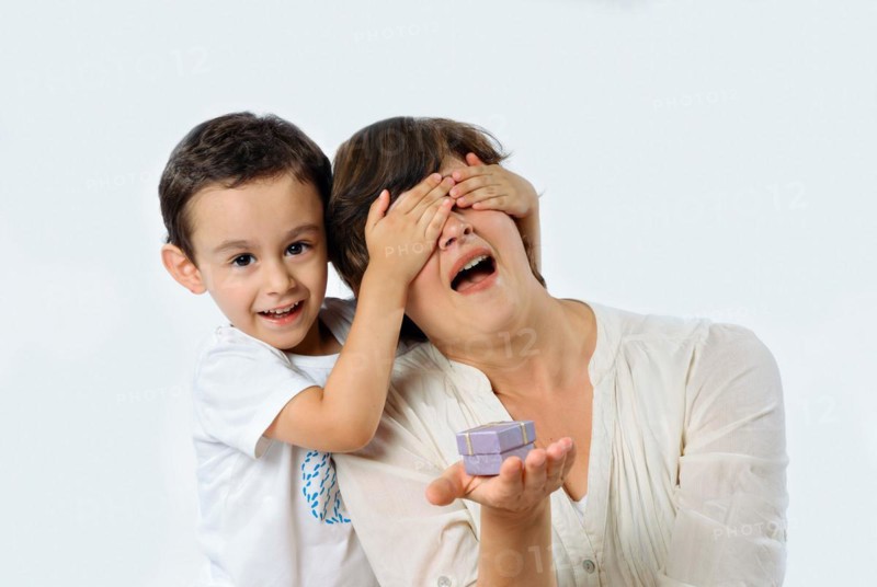 A child surprises his mom with a special gift on her birthday. Studio portrait on white background
