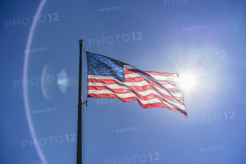 US flag waving in the wind. Vibrant colors over blue sky