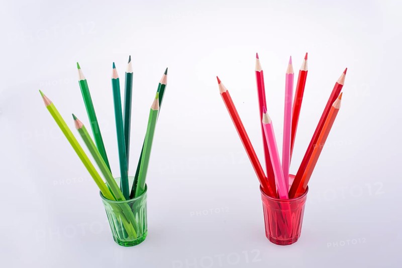 Color Pencils in colorful glasses on a white background
