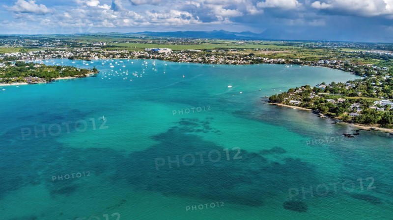 Aerial view from bird's eye view of large sea bay Grand Baie with pleasure boats motor yachts sailboats anchored in sheltered bay