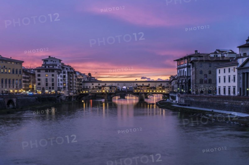 View of the iconic Ponte Vecchio over the Arno River at dusk in Florence