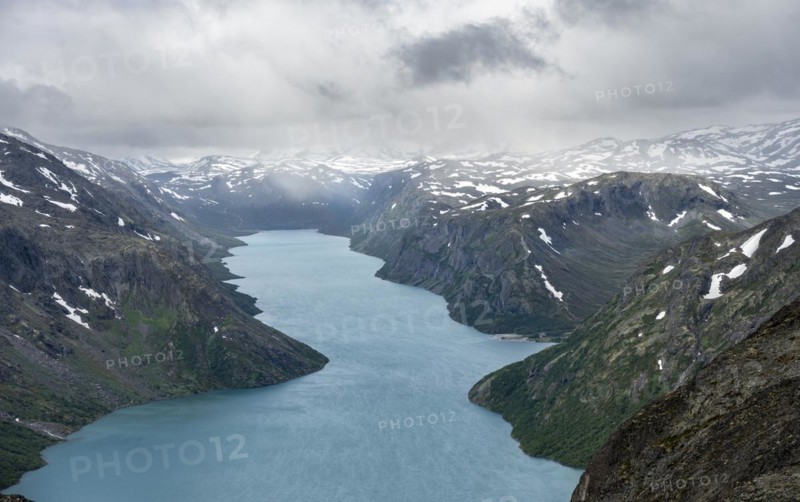 View of Lake Gjende and snowy mountains