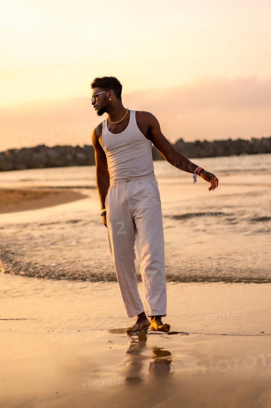 Portrait of black ethnic model enjoying summer vacation by the sea wearing a tank top