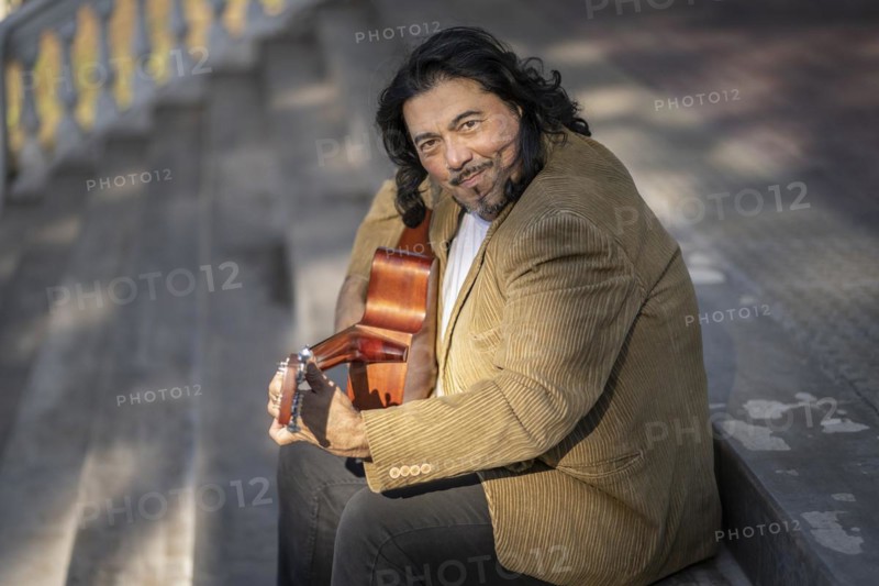 Flamenco guitarist sitting on some stairs performing