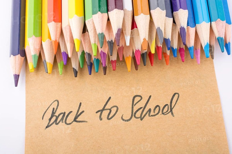 Color pencils and back to school title on a notebook