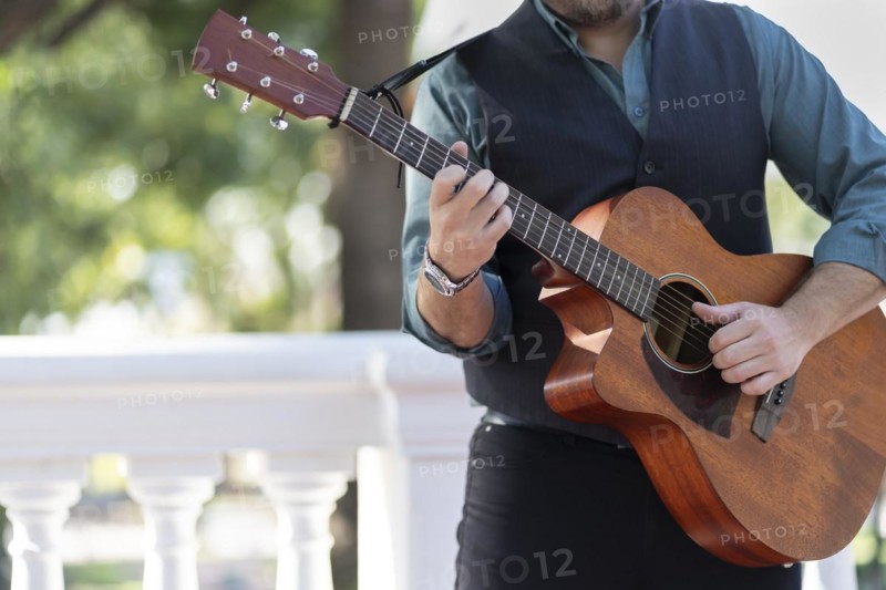 Professional guitarist plays guitar outdoors. Musician plays a classical guitar in the park