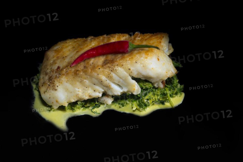 Cod fillet fried in nut butter on leaf spinach with a red chilli