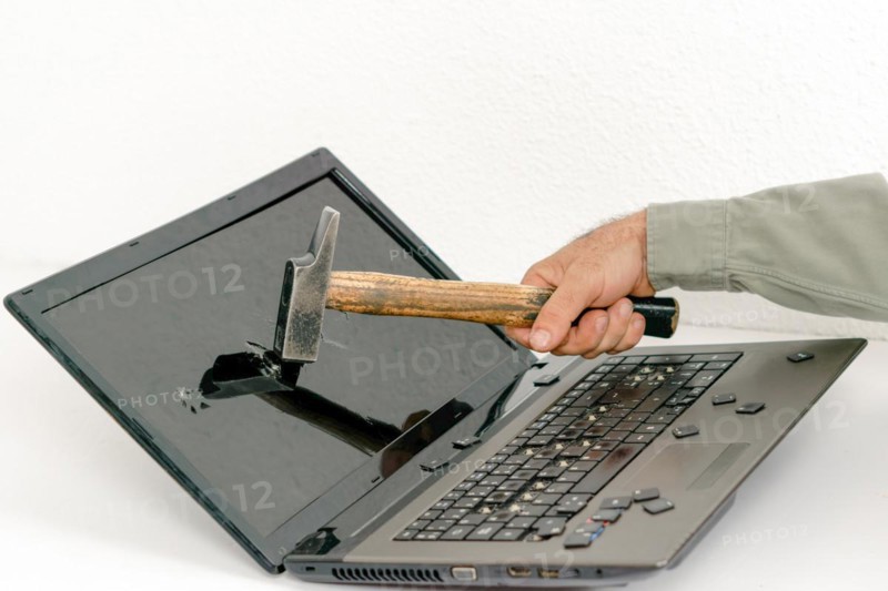 Arm of a man breaking a laptop with a hammer isolated on white background and copy space