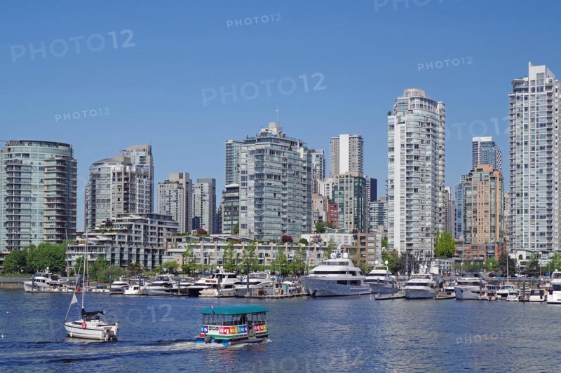 Small boats in front of yachts and skyscraper canyons