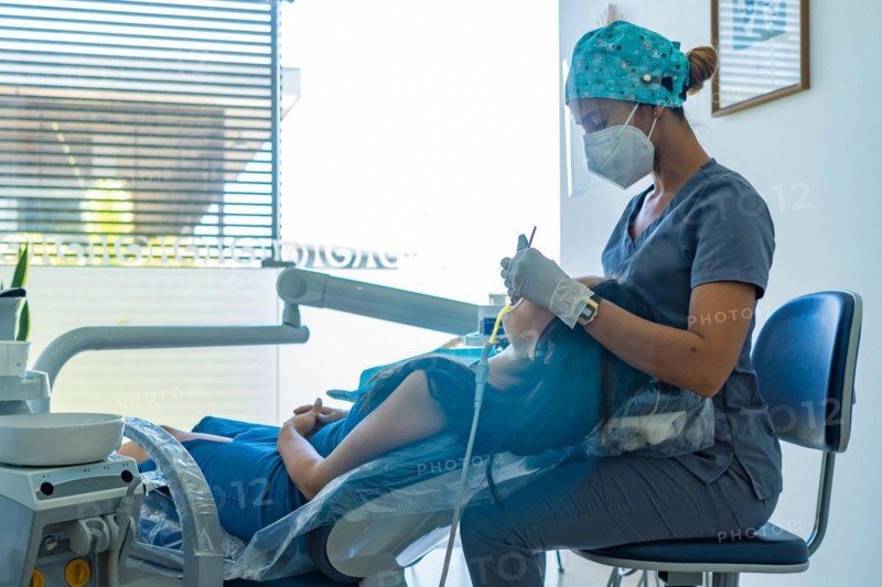 Medical professional dentist examines his patient's teeth with the use of special dental instruments