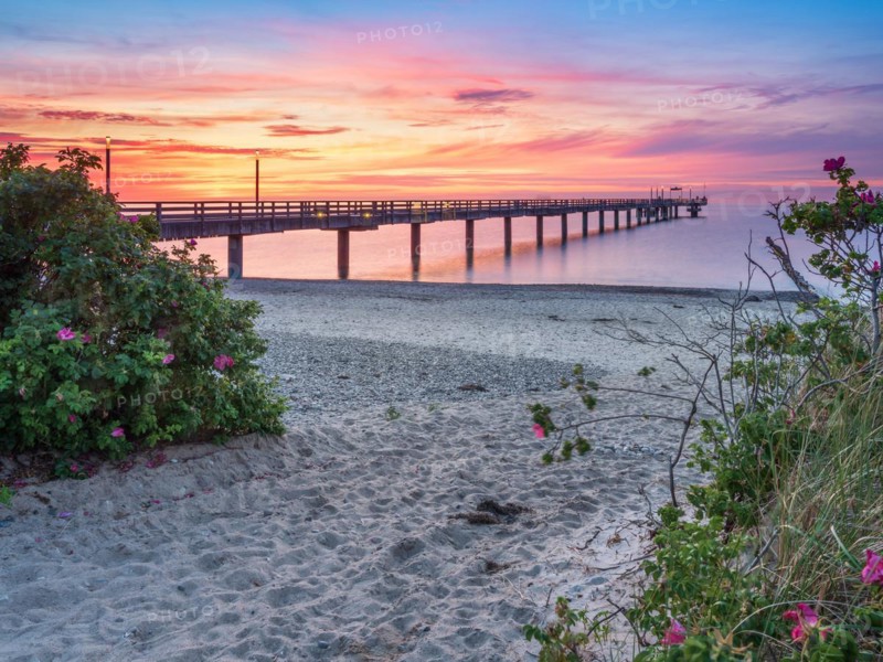 Pier on the beach of the Baltic Sea at sunset