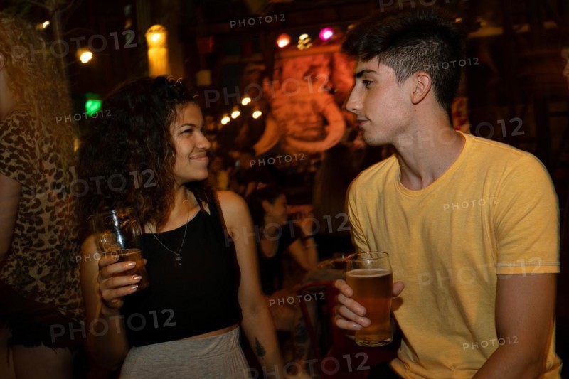 Young people flirting. Blurred background. Couple meet at a bar for a first date