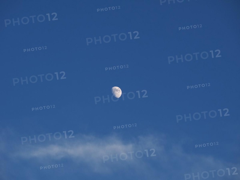 Waxing gibbous moon over blue sky