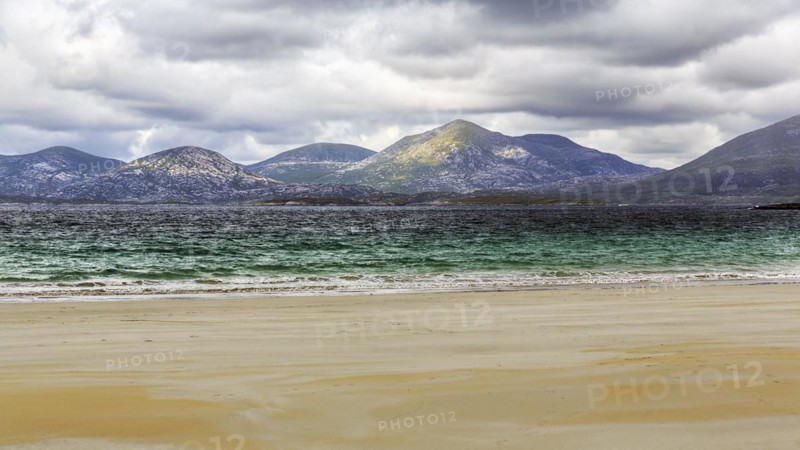View from the sandy Luskentyre Beach over the sea bay East Loch Tarbert to the mountains