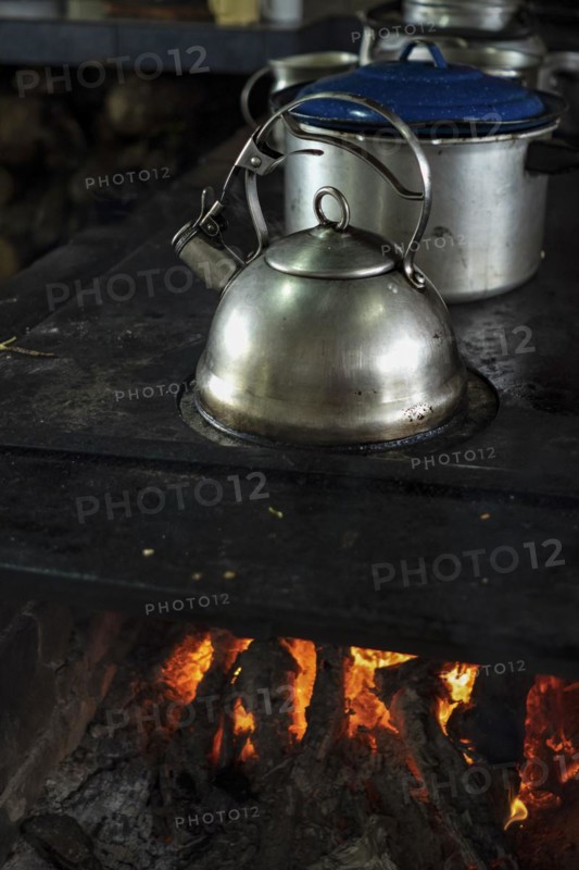 Close up of stainless steel kettle on a burning wood stove. Popular culture. Traditional food