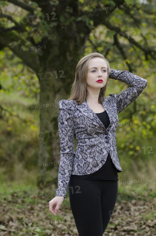 Beautiful young woman standing in the countryside looking away
