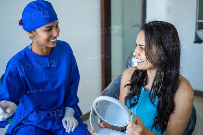 Female dentist talking to her patient at dentist's office. Concept of whitening