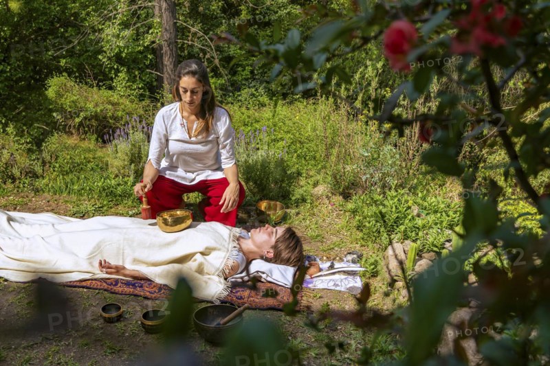 Tibetan singing bowls on belly and chest. Sound massage with singing bowls on the body. Vibrational therapy. Stress relief. Chakra alignment