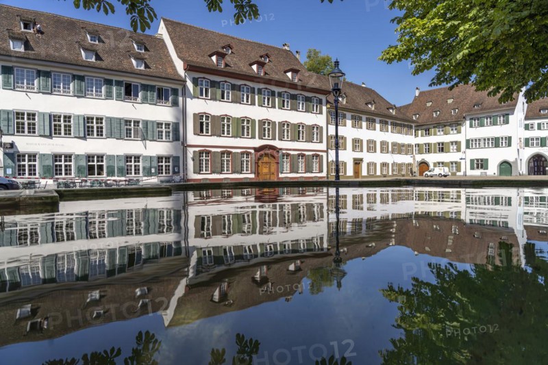 Cathedral houses reflected in the fountain on Muensterplatz in Basel