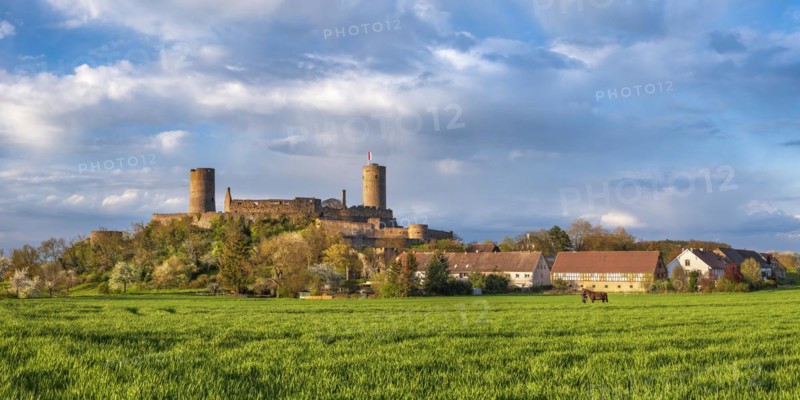 View of Muenzenberg Castle in the Wetterau under dark clouds in spring evening light