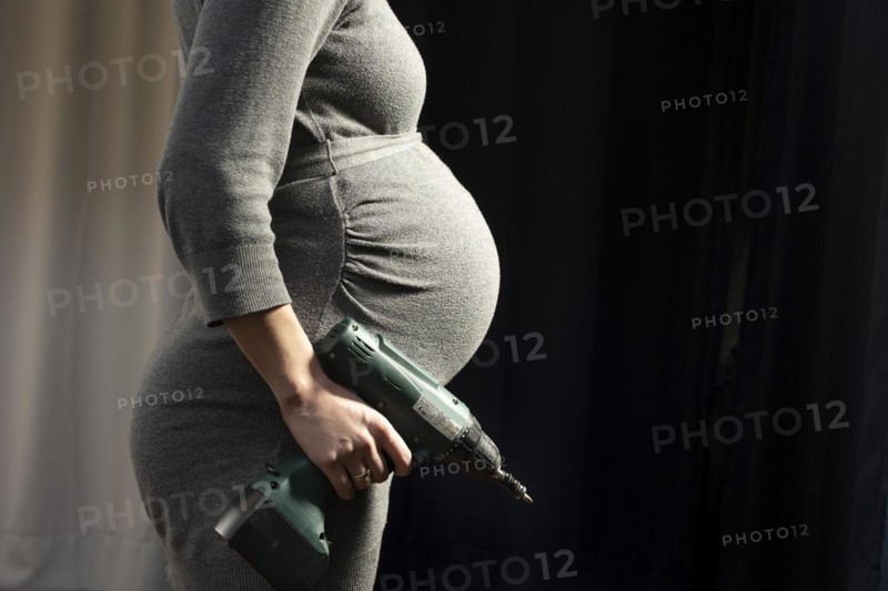 Pregnant woman with drill