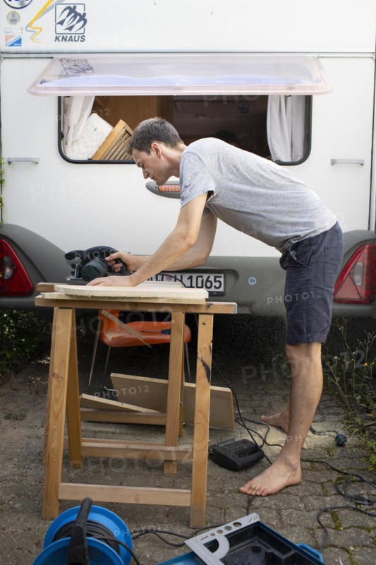 Man tinkering with his caravan.