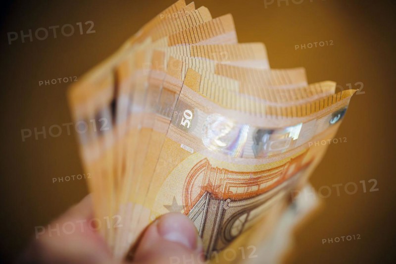 Symbolic photo on the subject of cash. 50 euro banknotes are held in one hand. Berlin