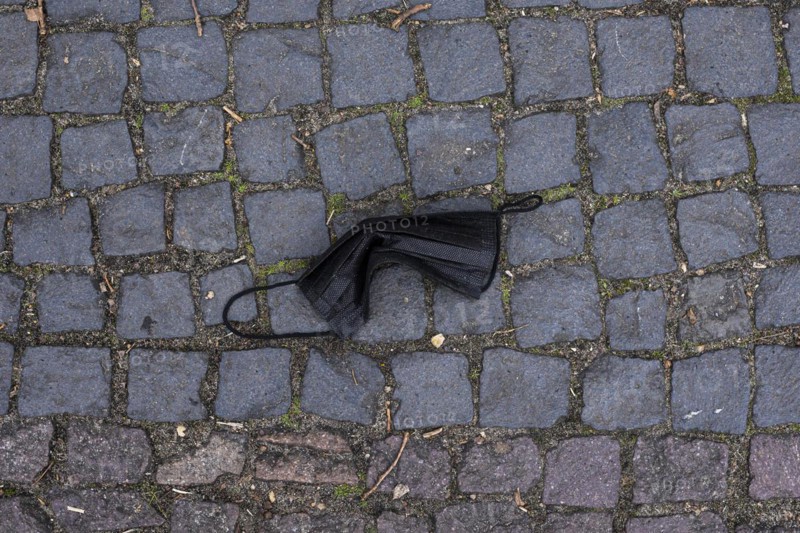 A discarded mouth-nose protection lies on the ground