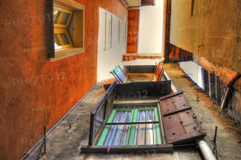 Narrow Patio Between Houses with Windows and Sky in Cannobio