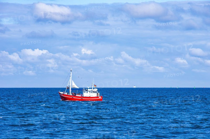 The fishing vessel PASEWALK leaves the harbour entrance with passengers and with a hoisted pirate flag towards the open sea