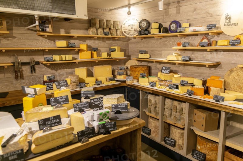 Variety of cheeses on display in cheese room of farm shop