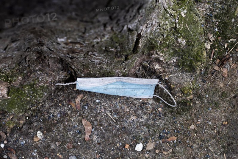 A discarded mouth-nose protection lies on the ground