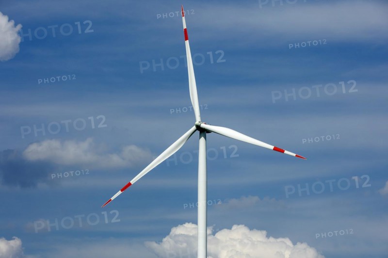 A wind turbine in summer rises into the sky in Luckau
