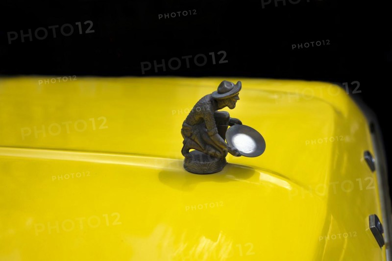 Gold washer as radiator mascot on an older Ford Pick Up