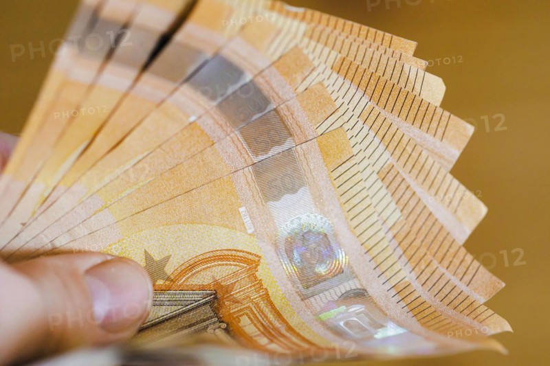 Symbolic photo on the subject of cash. 50 euro banknotes are held in one hand. Berlin