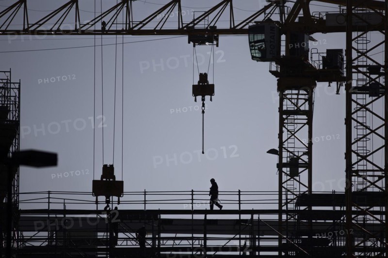 The silhouette of a scaffolder stands out on a construction site in Berlin