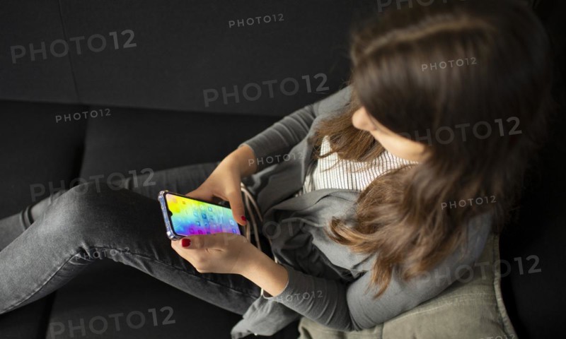 Subject: Teenagers with mobile phones on the sofa