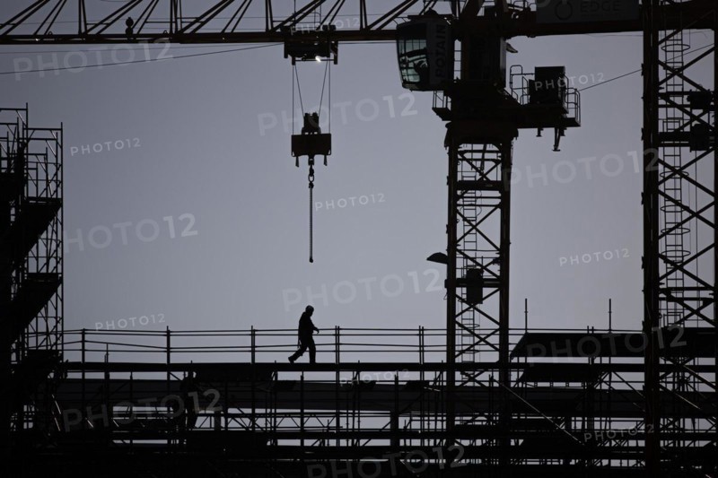 The silhouette of a scaffolder stands out on a construction site in Berlin