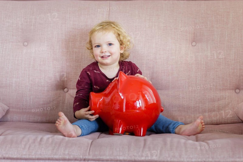 Child with piggy bank is happy.