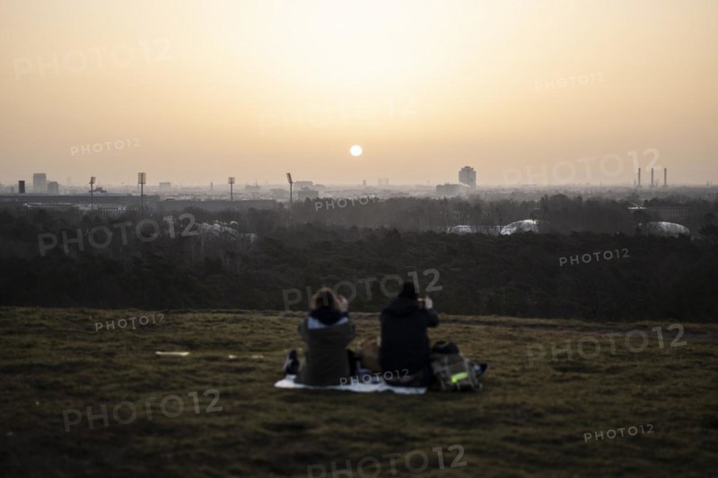 Two people silhouetted against the rising sun in Berlin
